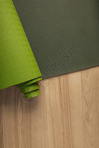 木桌上绿色的瑜伽垫背景图片