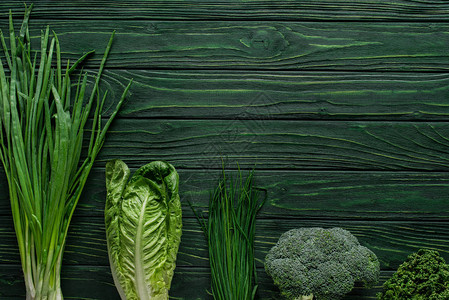 绿色洋葱花椰菜和木制桌上的马铃薯图片