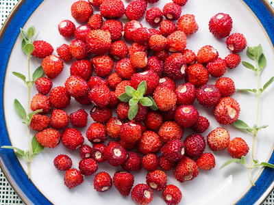 盘子上的野草莓和绿图片