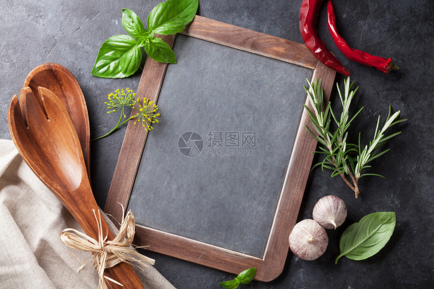 用于文字的黑板新鲜园艺药草和石桌上的香料巴西尔迷迭薄图片