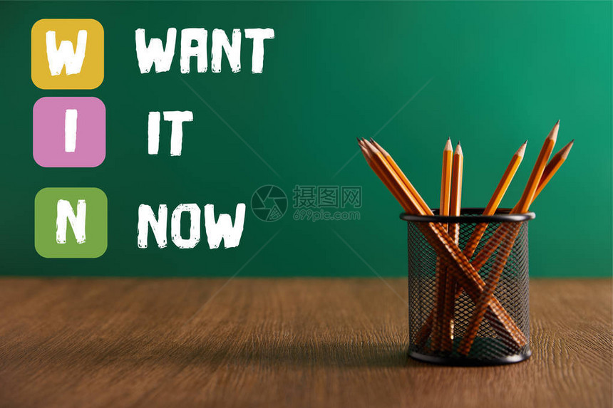 木制桌上的铅笔和背景上的绿色黑纸板WIN现在图片