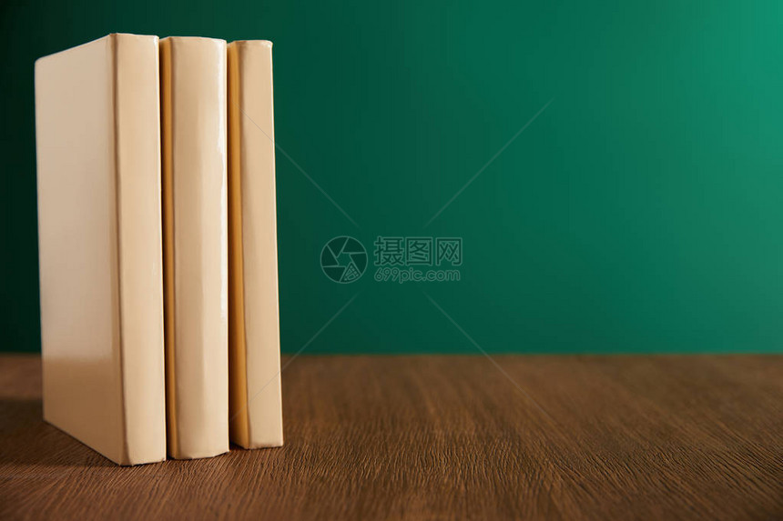 木桌上的三本书背景是黑板图片