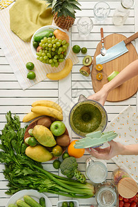 用水果蔬菜和蔬菜制作绿色冰沙的女图片