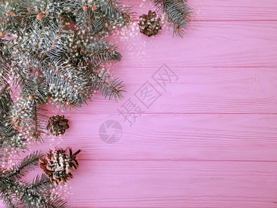 圣诞树枝粉红色木质背景上的一个凸起图片