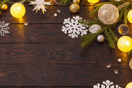 深色木质背景上带灯的圣诞装饰品图片