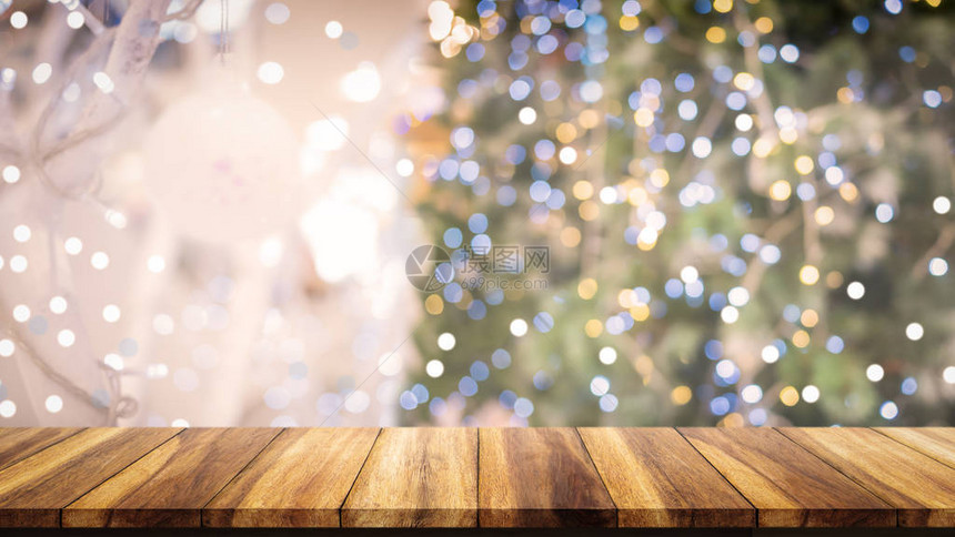 木质桌顶在模糊的圣诞树背景上用于显示或图片