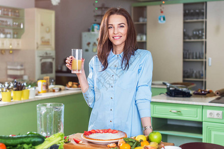 有吸引力的年轻模特装在厨房里拿着一杯果汁在普罗旺图片