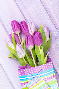 紫色的郁金香花束在木制桌子图片