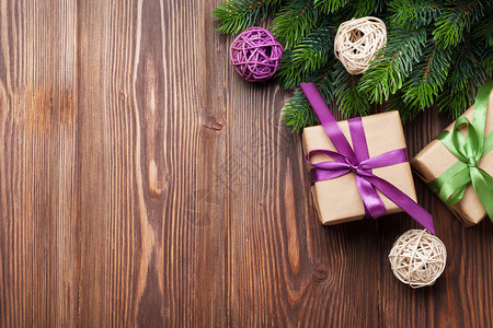 木制桌上的圣诞礼品盒和fir树顶视图图片