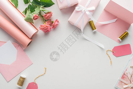 粉红玫瑰纸卷包裹的礼品信封和图片