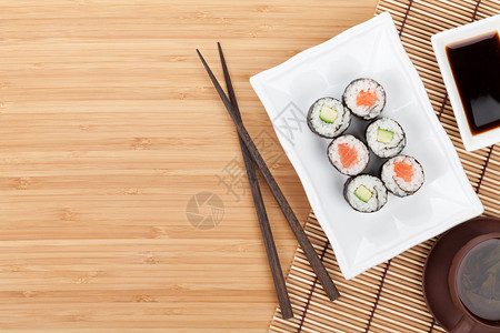 寿司筷子和酱油在竹桌上图片