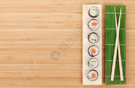 寿司配有三文鱼和黄瓜竹桌对面图片
