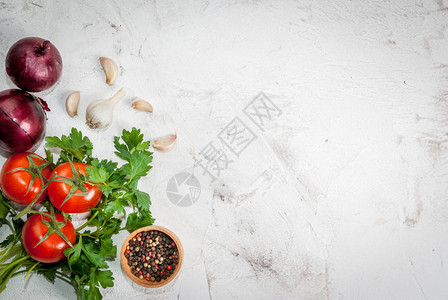 Spices黑胡椒大蒜洋葱绿菜和番茄烹饪的成分在白石块混凝土桌上图片