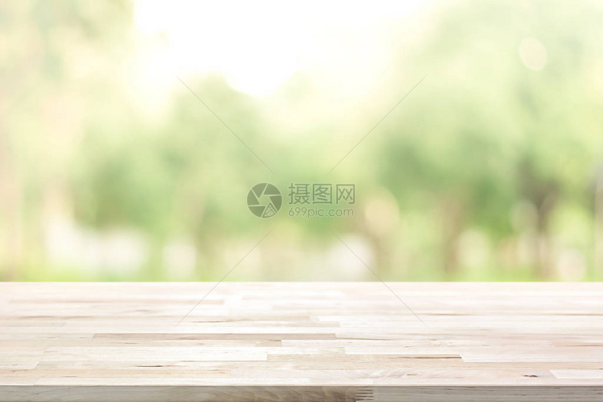 公园树木的模糊绿色背景上的木质桌顶图片