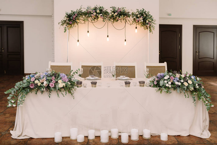 用鲜花蜡烛和灯具装饰婚礼主席团图片