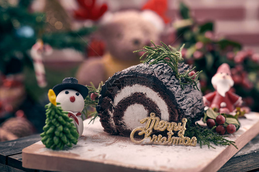 圣诞巧克力卷蛋糕与雪人圣诞老人糖圣诞树和蓝莓放在一起圣诞快乐和新图片
