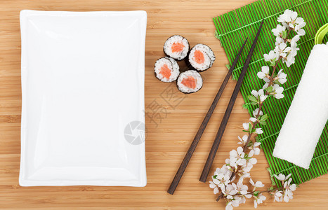 寿司卷与空盘在木桌上图片