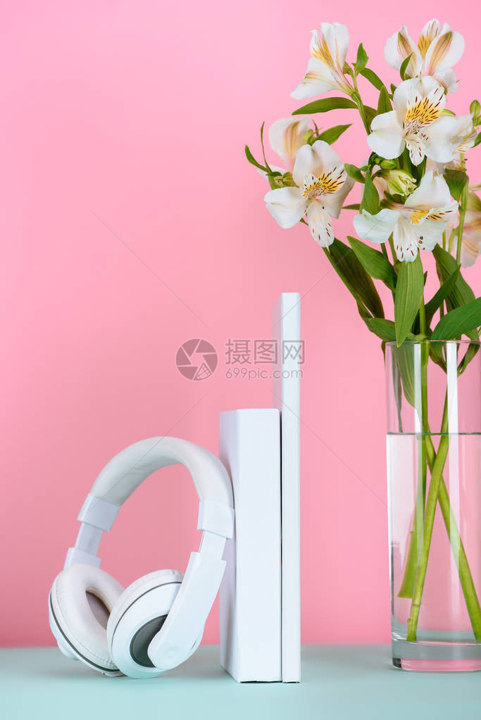 白色耳机和书桌上放着一束鲜花粉红色图片