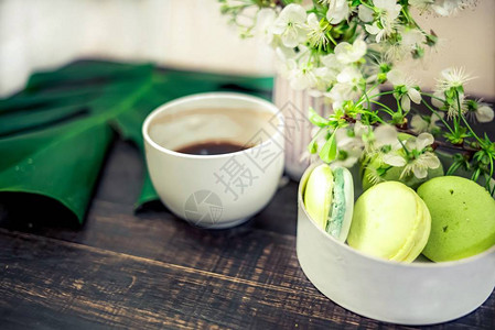 木桌上的绿色马卡龙咖啡或茶叶图片