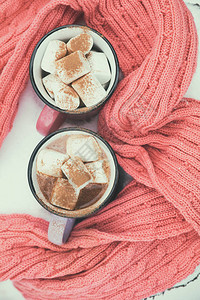 热巧克力和粉红色和紫罗兰色的棉花糖两个杯子图片