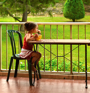 小女孩在阳台吃早餐图片