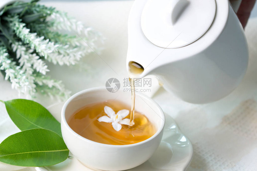 特写在白茶杯中倒热茉莉花茶道时间概念图片