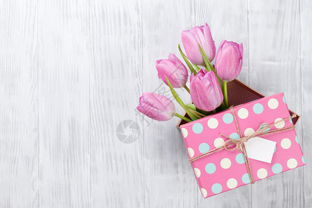 鲜粉红郁金香花装在木制桌图片
