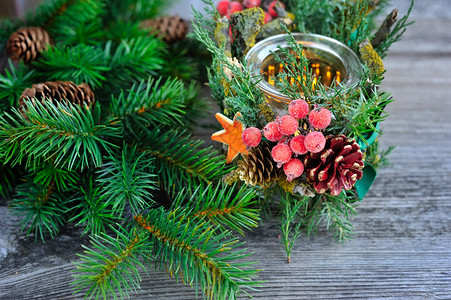 蜡烛和圣诞树枝放在木制桌子上自然图片