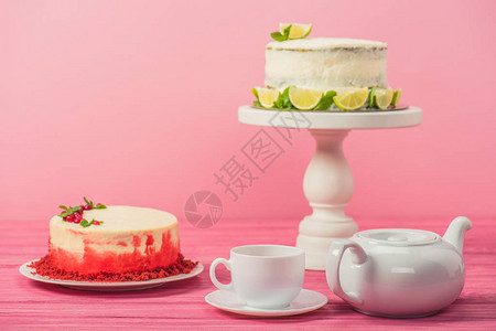 在粉红色上孤立的杯子和茶壶附近图片