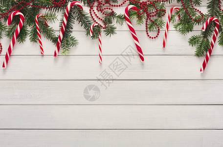 传统糖果甘蔗fir树枝和白木上的红弓边框图片