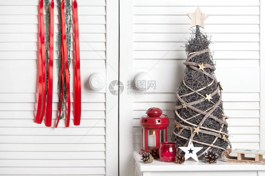 绿色红梦捕捉者红烛台和白色门背景的木圣诞树图片