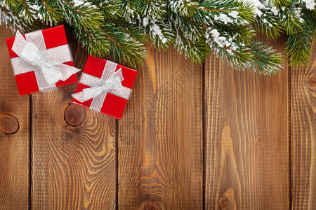 圣诞礼物盒和雪卷树木本上图片