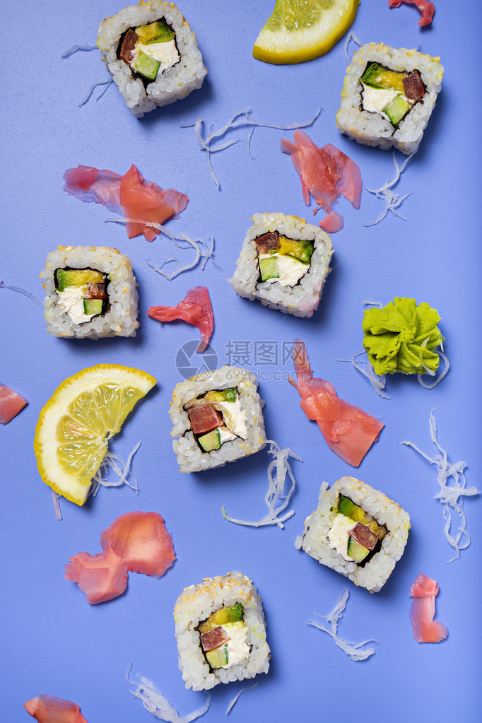 鲜蓝色背景中的寿司卷和配料图片