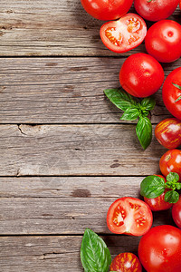 木制桌子上新鲜的成熟园艺番茄和巴西尔顶视图背景图片
