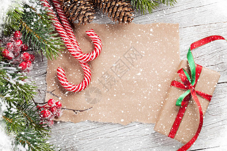 圣诞礼物盒糖果甘蔗和木制桌上的雪花果树您要用纸在顶端观图片