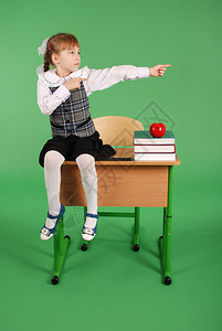 穿着校服的女孩坐在桌子上以绿色图片