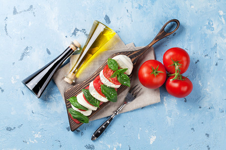 卡布雷斯沙拉莫扎雷拉奶酪西红柿和草药叶在石板图片