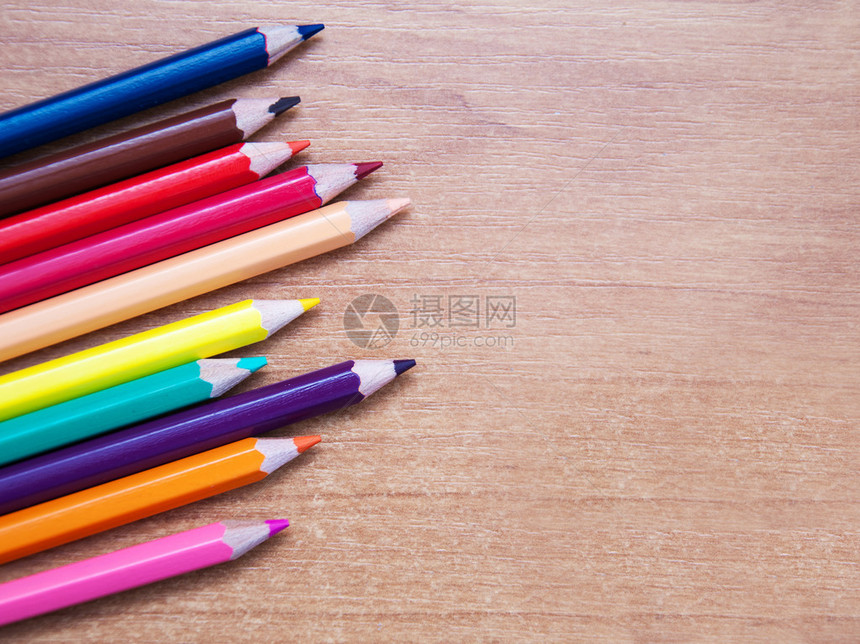 棕色木桌上的彩色铅笔图片