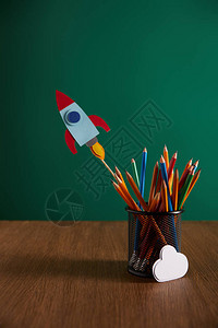 彩色铅笔火箭在木桌上的云牌和图片