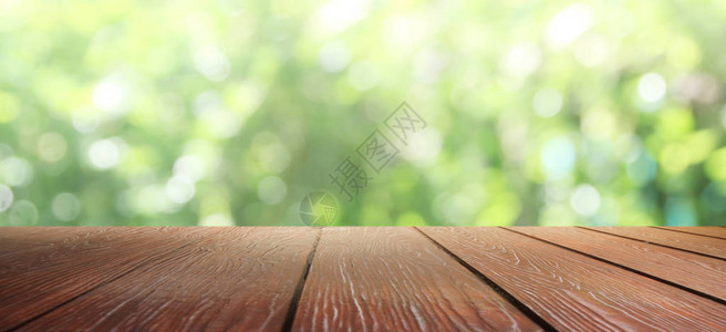 自然背景Wood桌在模糊的绿背景图片