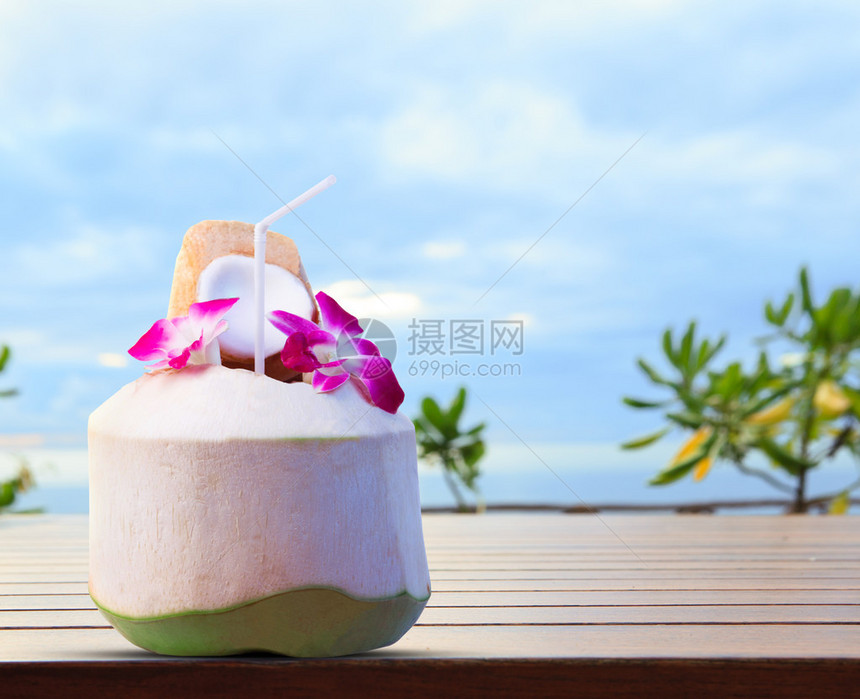 热带旅游目的地欢迎饮用绿椰子和兰花图片