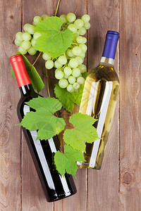 木桌上的一串葡萄红白葡萄酒瓶图片