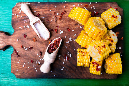 用盐和红干辣椒在木板上烤玉米片顶视图图片