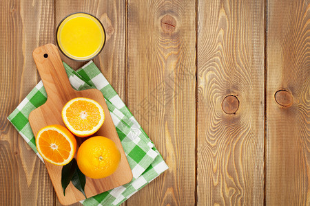 橙子和果汁杯从上面的木板背景上查看图片