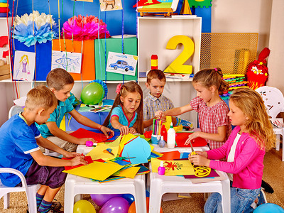 团体儿童在幼儿园学习和持有彩色纸和胶图片