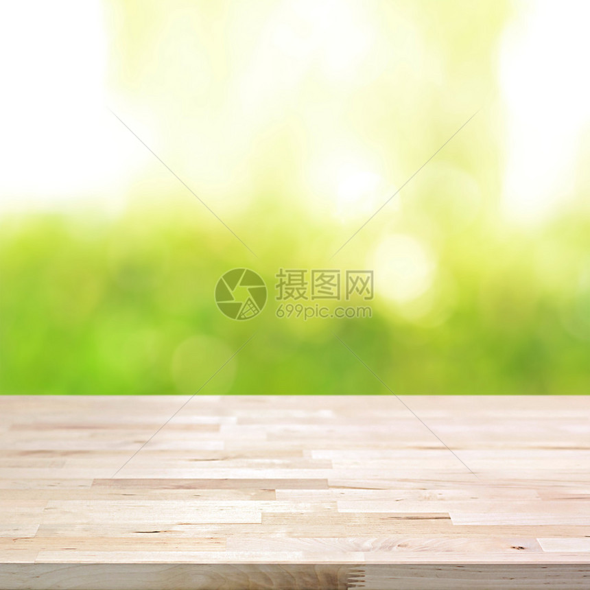 Bokeh抽象绿色背景上的木板表顶部可用于补装或图片
