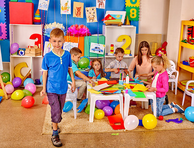 学龄前儿童群体中持有彩色纸和桌上胶水的内地幼图片