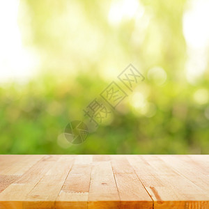 在bokeh绿色抽象背景上的木质表顶部图片