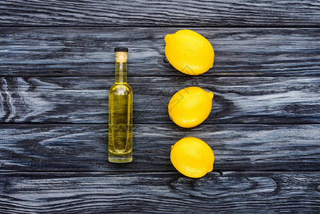天然草药基本油和木质表面3个柠檬的图片