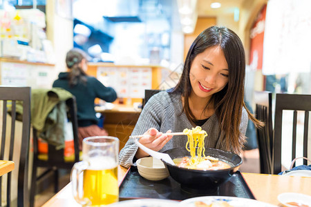 在日本拉面店吃拉面的女人图片